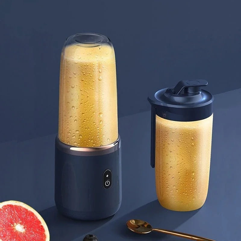 Two mini blender cups with translucent sides and golden drink, one with lid